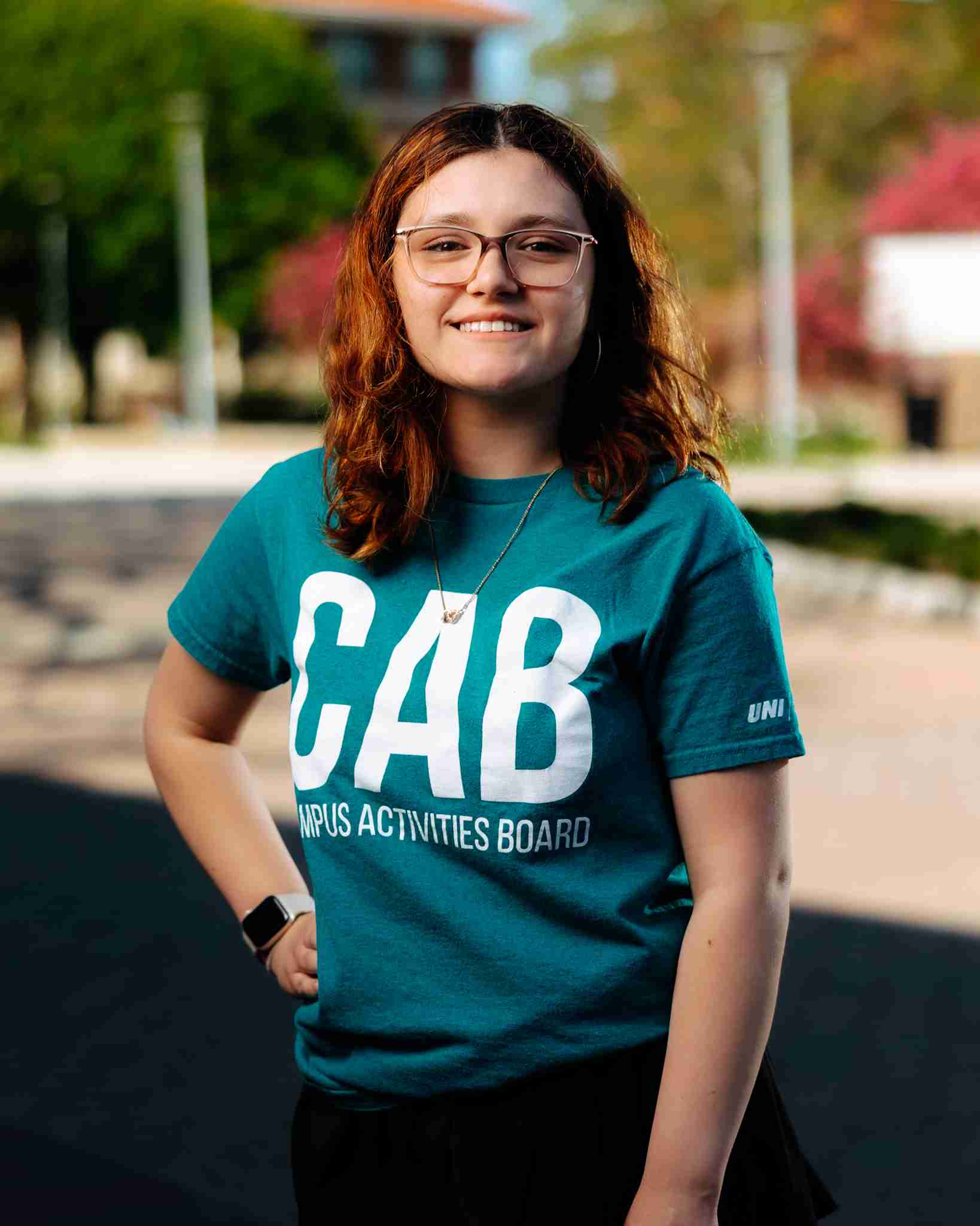Girl standing outside wearing teal shirt