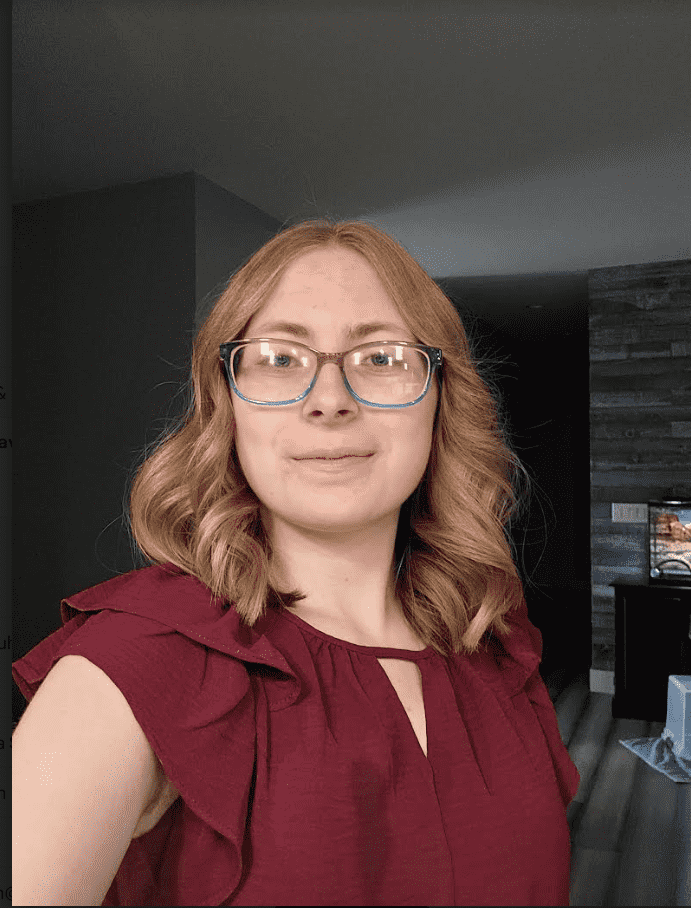 Girl wearing red shirt and glasses standing inside
