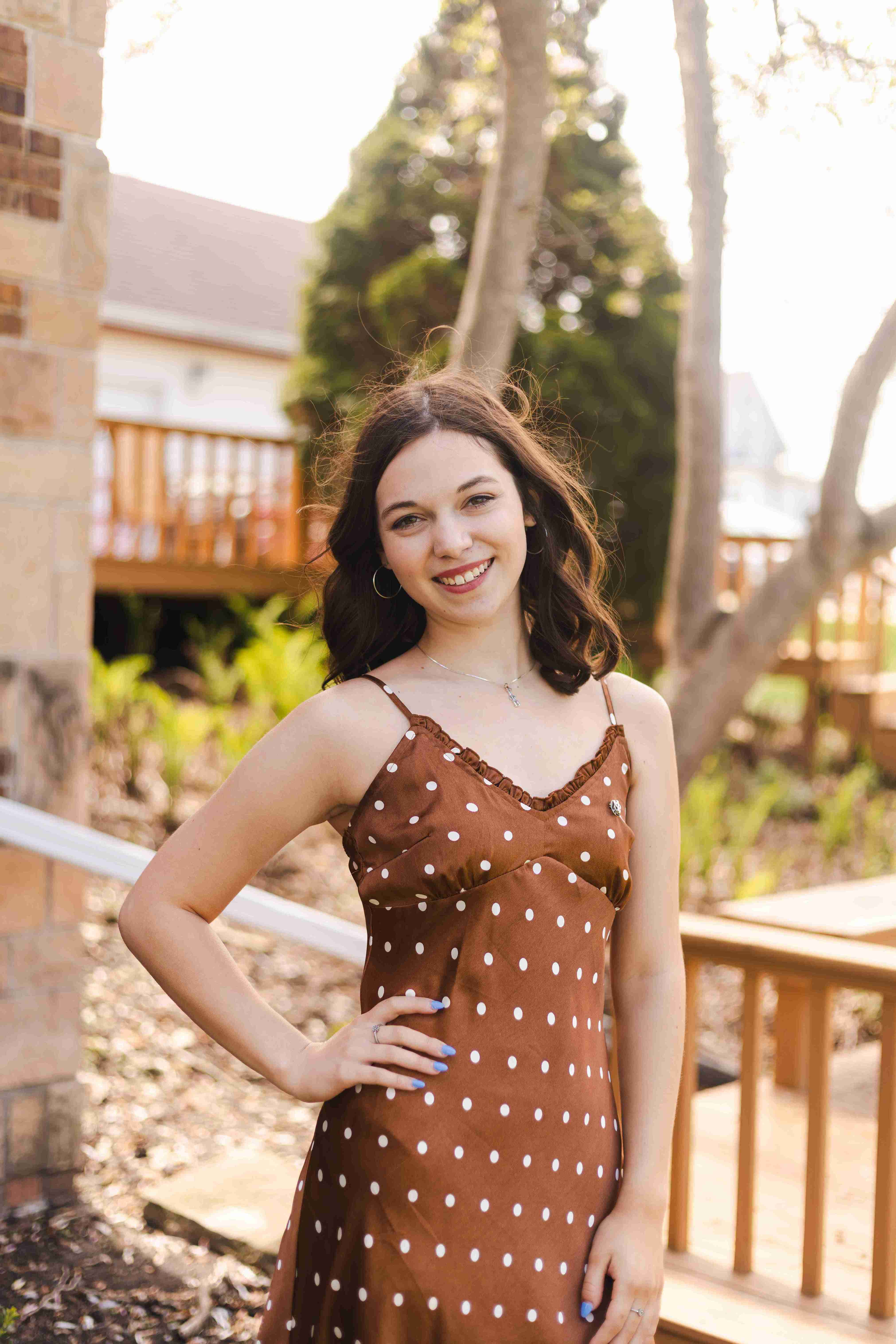 Girl standing outside in a brown dress
