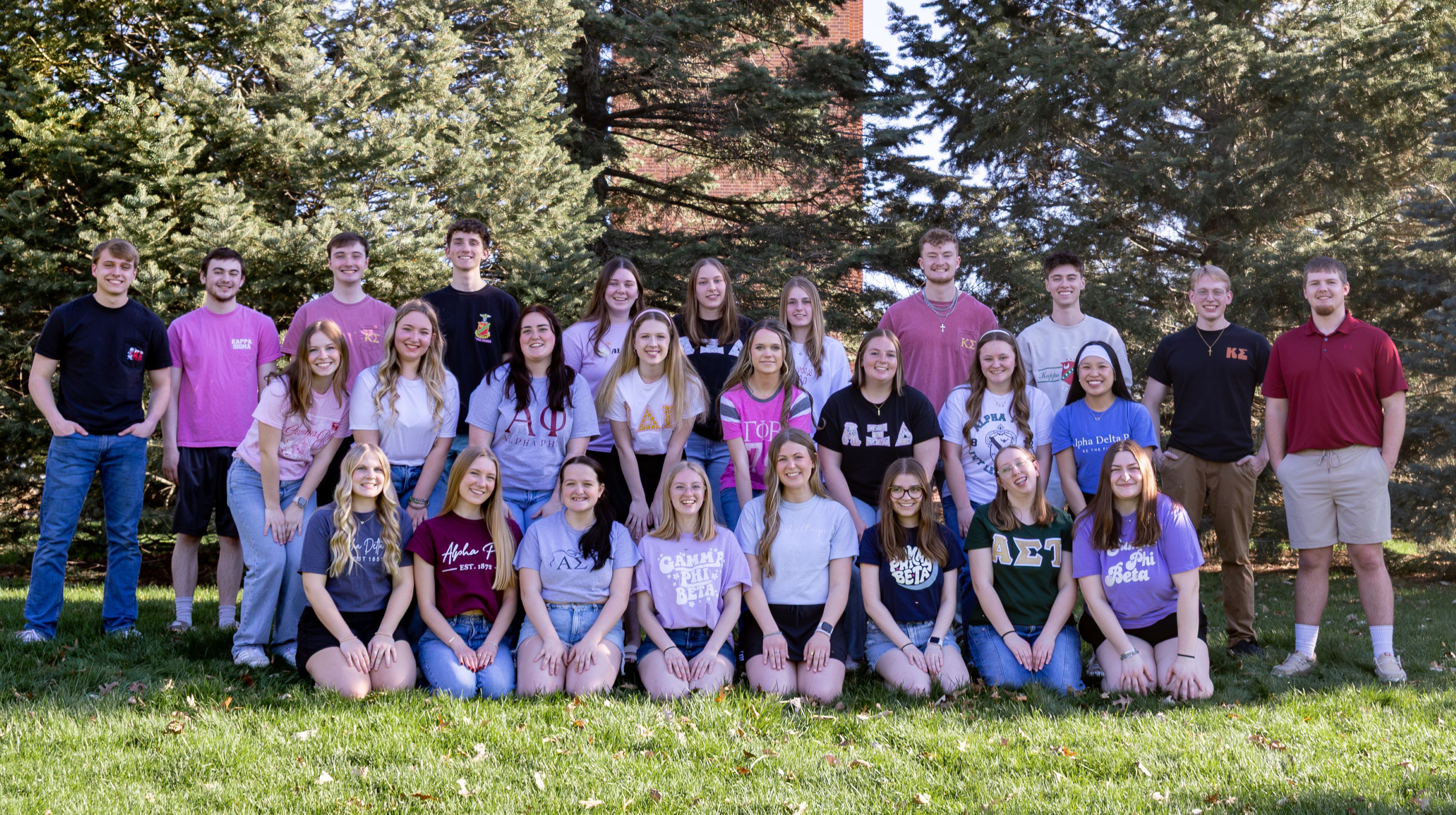 Group of Fraternity and Sorority Students posing in front of trees